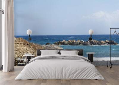 Parasol and veil that is spread on the pebbles on the beach near the sea Wall mural