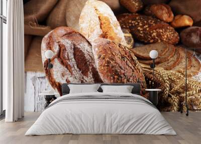 Assortment of baked bread and bread rolls on rustic white bakery table background Wall mural