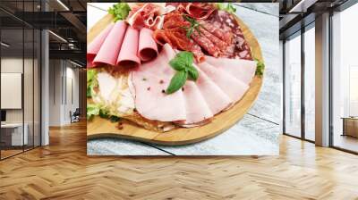 Food tray with delicious salami, pieces of sliced ham, sausage and salad. Meat platter with selection. Wall mural