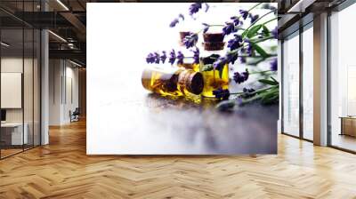 lavender oil in a glass bottle on a background of fresh flowers. Wall mural