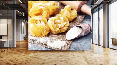 Making homemade pasta linguine on rustic kitchen table with flour, rolling pin and pasta. Wall mural