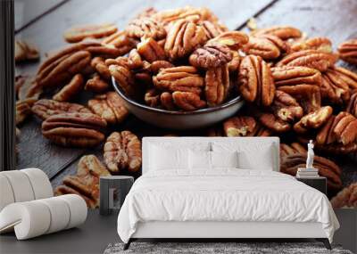 Pecan nuts on a rustic wooden table and pecan nuts in bowl Wall mural