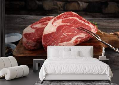 Raw fresh meat Ribeye Steak, seasoning and meat fork on dark background Wall mural