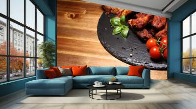 Spicy hot grilled spare ribs from a summer BBQ served with fresh tomatoes on an vintage cutting board Wall mural