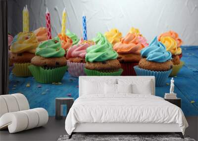 Tasty cupcakes on wooden background. Birthday cupcake in rainbow colors Wall mural