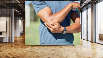 Sports man with elbow pain on arm, injury in outdoor soccer field. Hand massage bone, person with emergency muscle problem, physiotherapy in sport and joint accident with physical therapy Wall mural