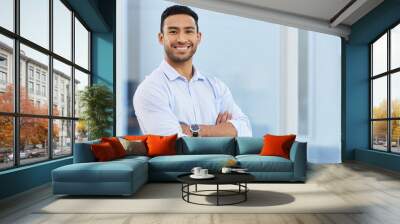 The business world wont know what hit them. Shot of a handsome young businessman standing alone in his office with his arms folded. Wall mural