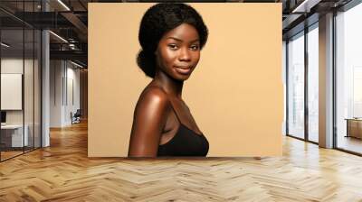 Beautiful african american woman with curly hair against beige background Wall mural