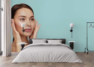 Moisturizing and facial treatment. Beauty portrait of beautiful model with perfect skin touching her face. Web banner with cope space Wall mural