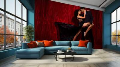 Photo of attractive tender gentle couple dancing hot salsa on stage isolated over red fabric background Wall mural