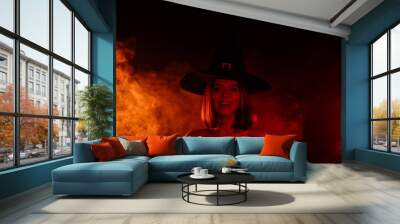 Photo of devil lady wear witch hat smiling isolated orange mist smoke background Wall mural