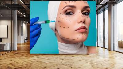 Photo of lady plastic surgery patient having injection with botox filler in cheeks over cyan color background Wall mural