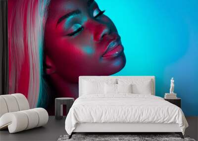 Portrait of young stunning gorgeous peaceful african woman sensual shot isolated on blue vivid background Wall mural