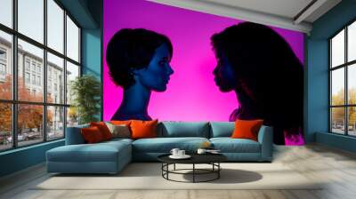 Profile side view portrait of two attractive alluring women vs looking at each other isolated over vivid violet purple neon color background Wall mural