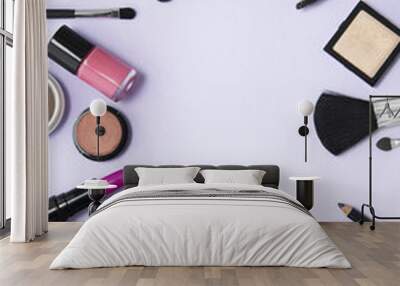 Make up and cosmetic beauty products arranged on a pale purple background, with blank space in the middle Wall mural