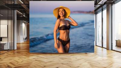 Pretty brunette woman relaxing on the beach at the sea. Wall mural