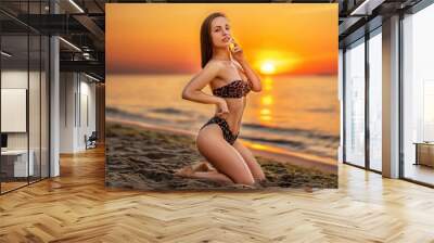 Pretty brunette woman relaxing on the beach at the sea. Wall mural