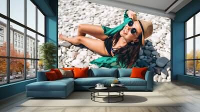 Pretty pan asian travel girl relaxing on the beach at the sea in green pareo. Wall mural