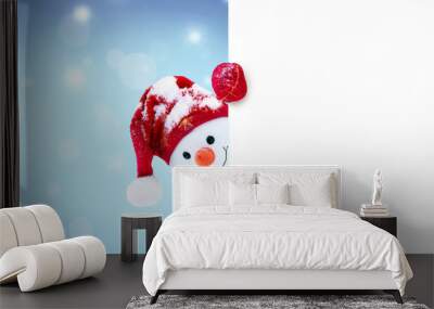 little snowman in caps and scarfs on snow in the winter. background with a funny snowman. christmas  Wall mural