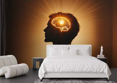 Silhouette of a person with a glowing brain inside their head with radiating light. Wall mural