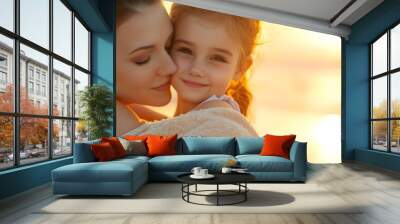 A loving embrace between a Caucasian mother and her young daughter at sunset. Wall mural