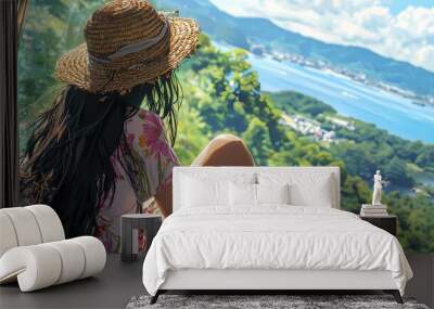 A young woman enjoying a scenic view in a straw hat and floral dress. Wall mural