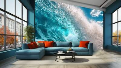 Vibrant ocean wave crashing under a blue sky with fluffy clouds. Wall mural