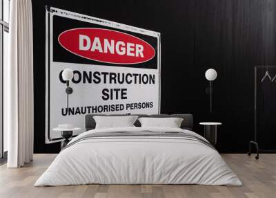 Construction Site Danger Sign Against Black Fence Wall mural