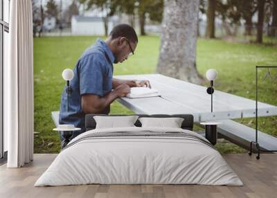 African-American male sitting at a table and reading the Bible Wall mural