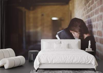 Closeup of a female with the bible against her head while praying Wall mural