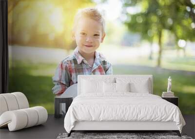 Closeup shot of a child holding an open bible while looking at the camera with blurred background Wall mural