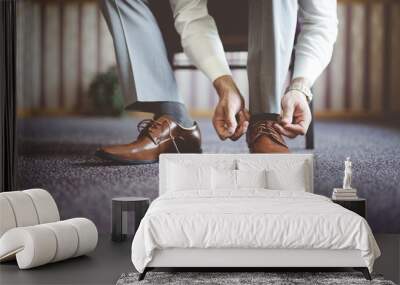 Closeup shot of a male tying his shoes and getting ready for a business meeting Wall mural