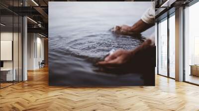 Closeup shot of a person wearing a biblical robe washing his hands in the water Wall mural