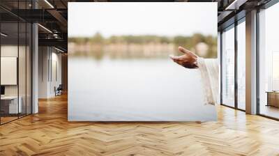 Closeup shot of Jesus Christ lending a hand for help with a blurred background Wall mural