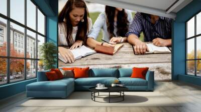 Closeup shot of people sitting and reading the bible with a blurred background Wall mural