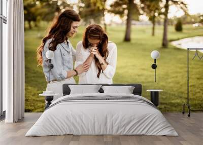 Closeup shot of two female praying with a blurred background Wall mural