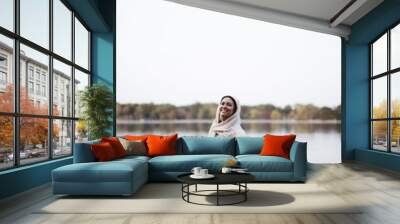 Vertical shot of a female wearing a biblical robe while standing in the water and smiling Wall mural