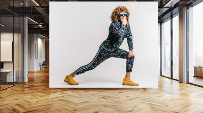 Adult positive smiling funky man with curly hair style in suglasses and vintage clothes posing on white studio background. Funny portrait of stylish male person. 80s fashion. Unusual eccentric guy. Wall mural