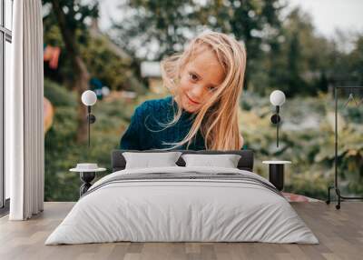 Portrait of young lovely girl lies on the coverlet in the garden and smile Wall mural