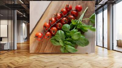 Fresh Italian sweet basil and tomatoes on a kitchen table in front of an open window at sunset Wall mural