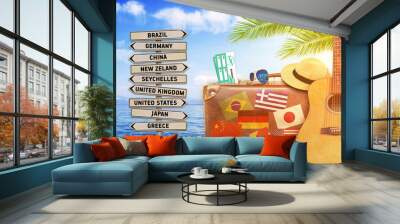 Concept of summer traveling with old suitcase and burning sun Wall mural