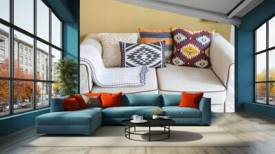 colorful pillow with native american pattern on beige sofa in living room. Wall mural