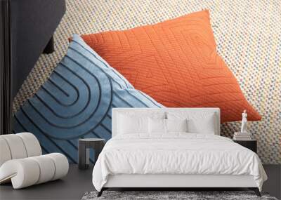 Modern and luxury pillow lying on carpet and sofa in living room. Blue, red, and orange pillow in room. Wall mural