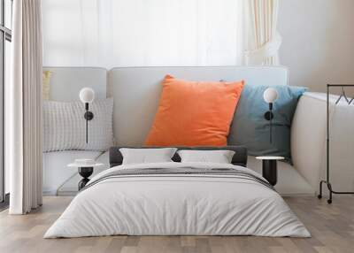 Orange and blue pillows on sofa in home Wall mural