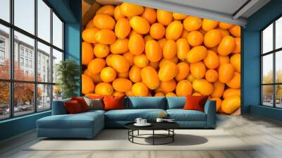 Heap of orange kumquats in cardboard box Wall mural