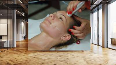 young woman during cosmetic facial treatment Wall mural