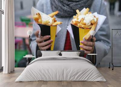 Belgian frites or french fries with mayonnaise in Brussels, Belgium. Female tourist holds two portions of fries in hands in the street. Wall mural