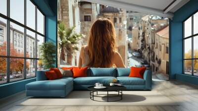 Female tourist looking at old town from balcony. Wall mural