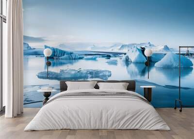 Serene view of the jokulsarlon glacier lagoon in iceland, featuring vivid blue icebergs against a backdrop of snowy mountains under a clear sky.  Wall mural