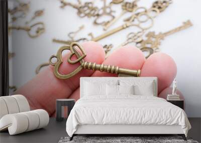 Heart shaped retro valentine metal key in hand Wall mural